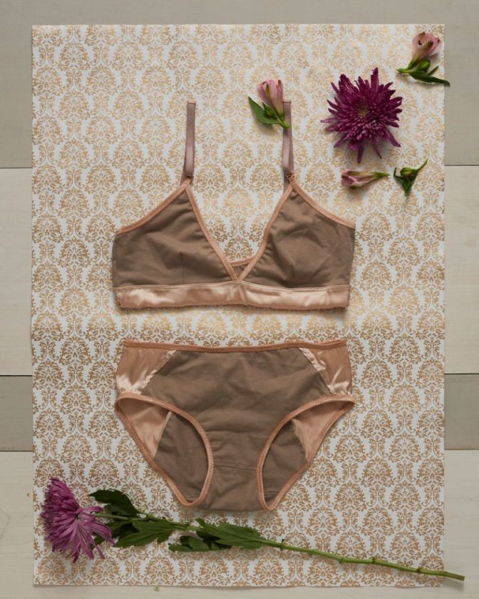 beige organic lingerie laying flat on gold embossed paper