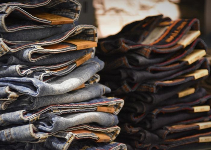 stack of mass produced jeans - fashion's overproduction problem article cover image