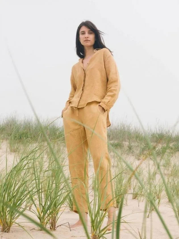 woman wearing mustard yellow linen trousers and linen top - sustainable linen clothing brands