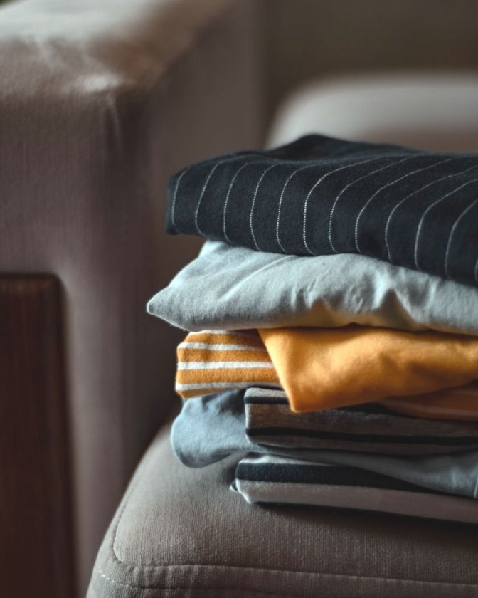 Clothing pile on chair - The Truth About What Happens to Donated Clothes