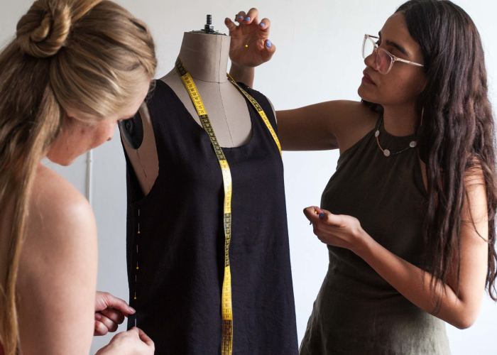 Two designers around mannequin with dress - sustainable fashion education